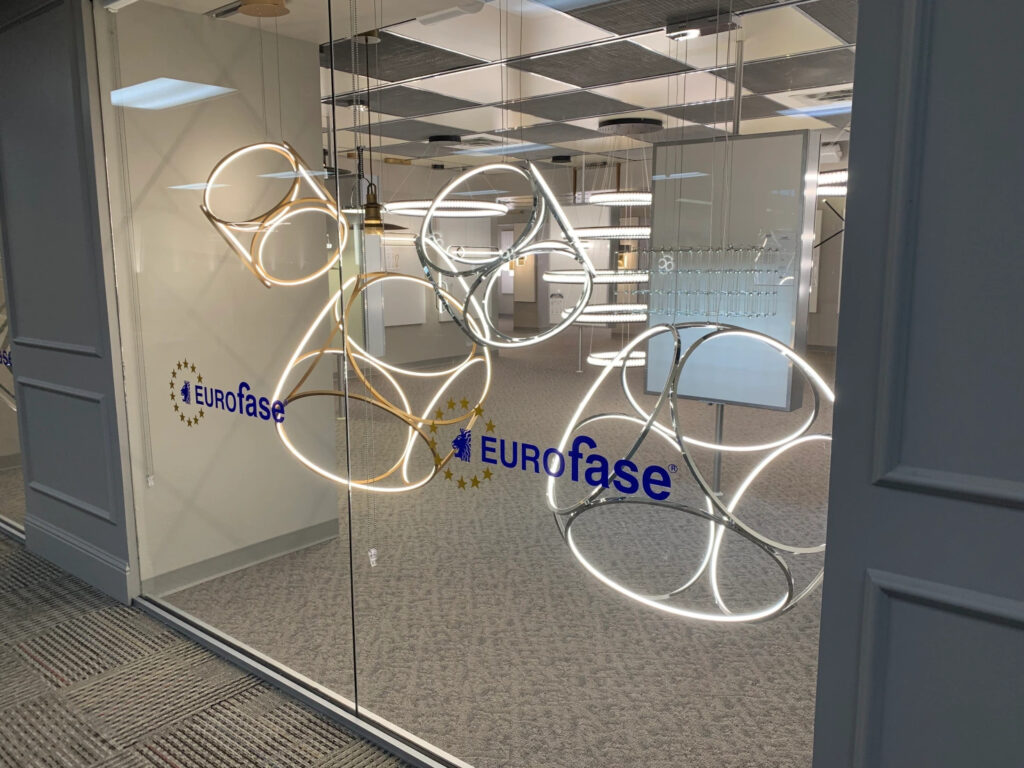 A glass wall display holds LED light sculptures with the label "Eurofase"