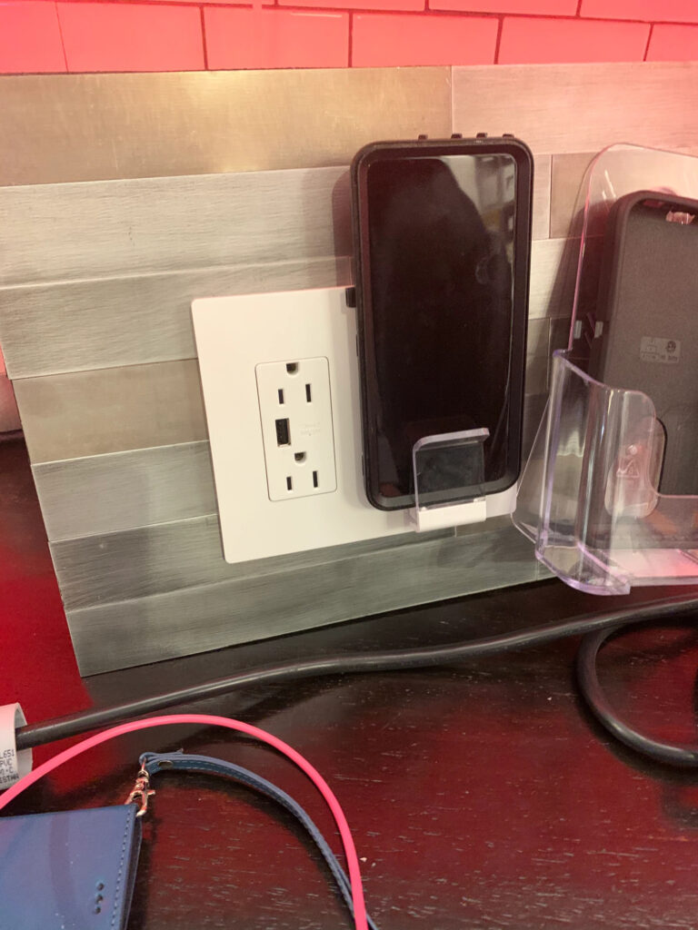 A mock up of a kitchen counter with a wireless phone charger holding a phone plugged into an outlet