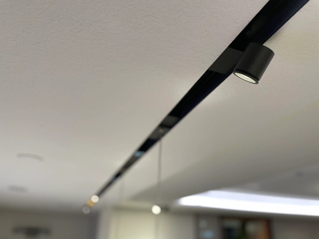 Close up of a black lighting strip on a white ceiling
