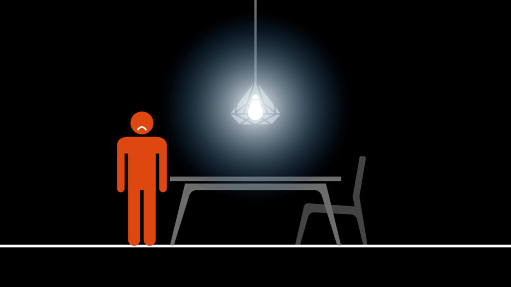 An illustration of a red person with a frown standing on the left of a table with a bright diamond shaped light hanging above it