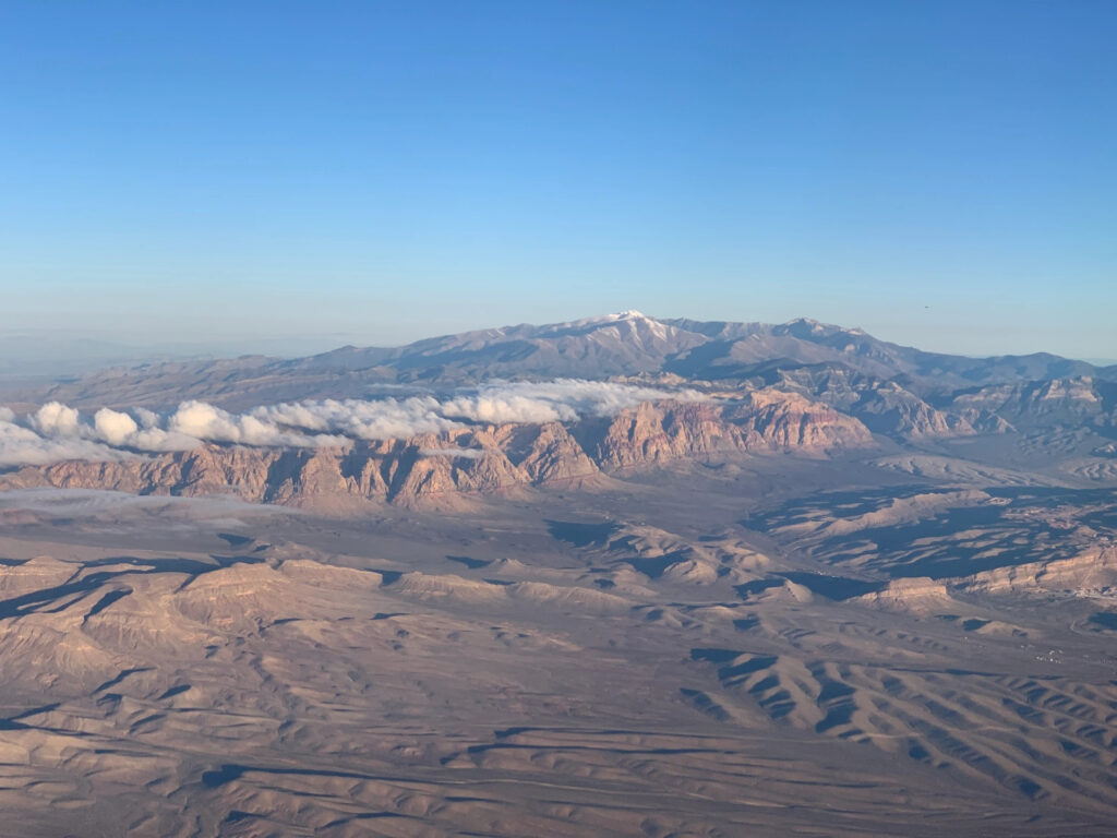 A view of a brown, barren mountain range from the height of an airplane