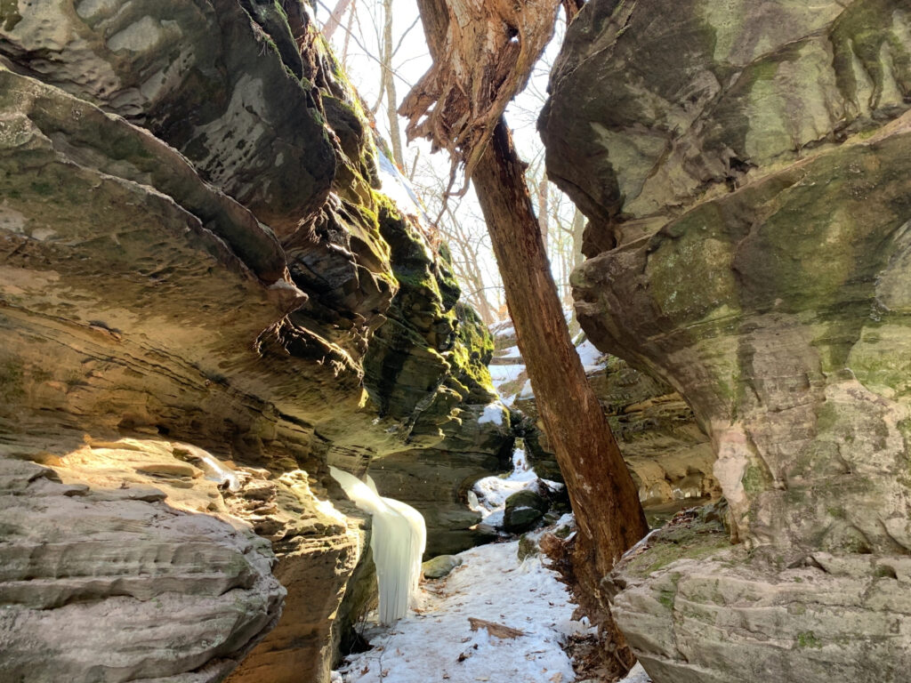 A rocky crevice covered in snow and ice on a sunny day near Madison, WI