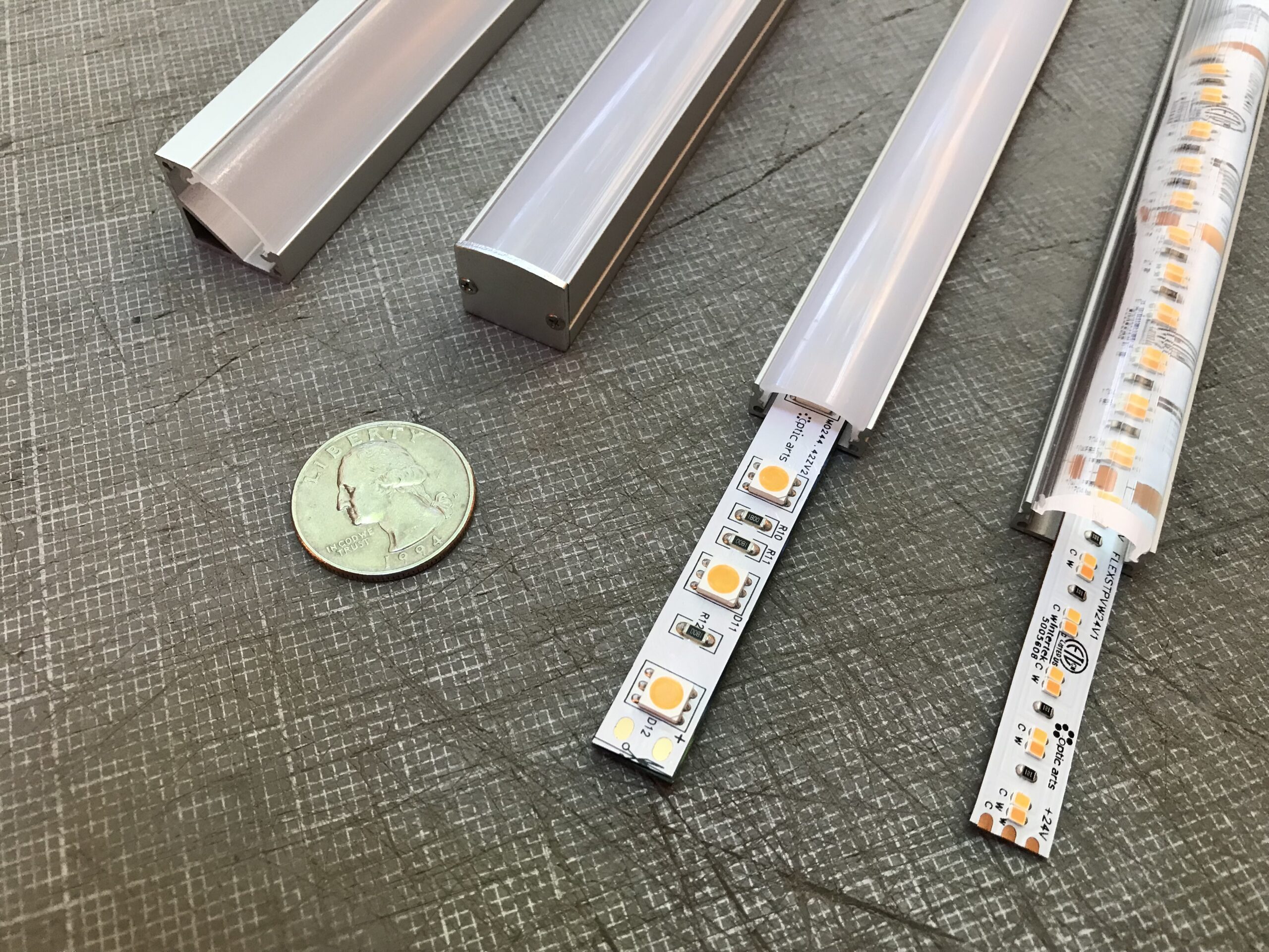 A photograph of LED strip lights being compared to a quarter, which is presented for size and scale.
