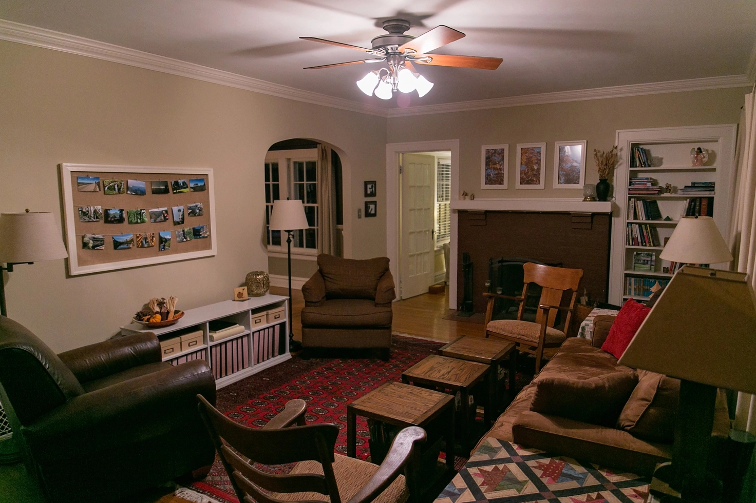 A living room packed with seating and tables with a ceiling fan light on