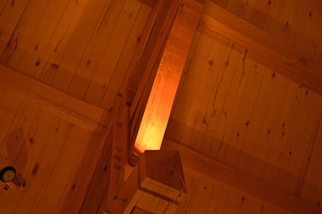 A photograph of a light on a ceiling beam inside a great room